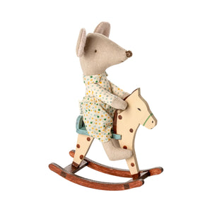 Toy mouse in pajamas riding a wooden rocking horse on a white background