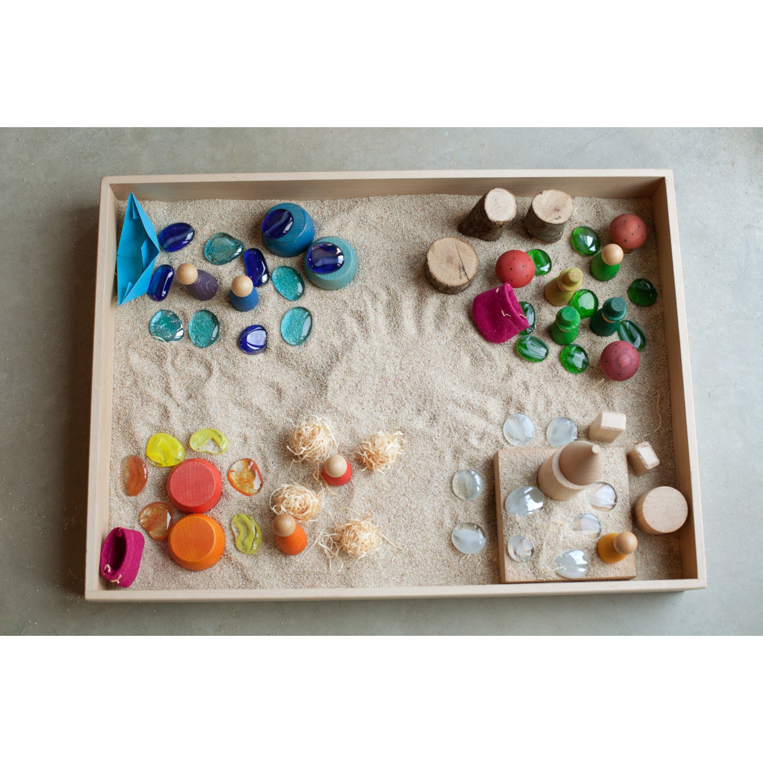 Grapat wooden tray filled with sand and colourful natural toys to invite play