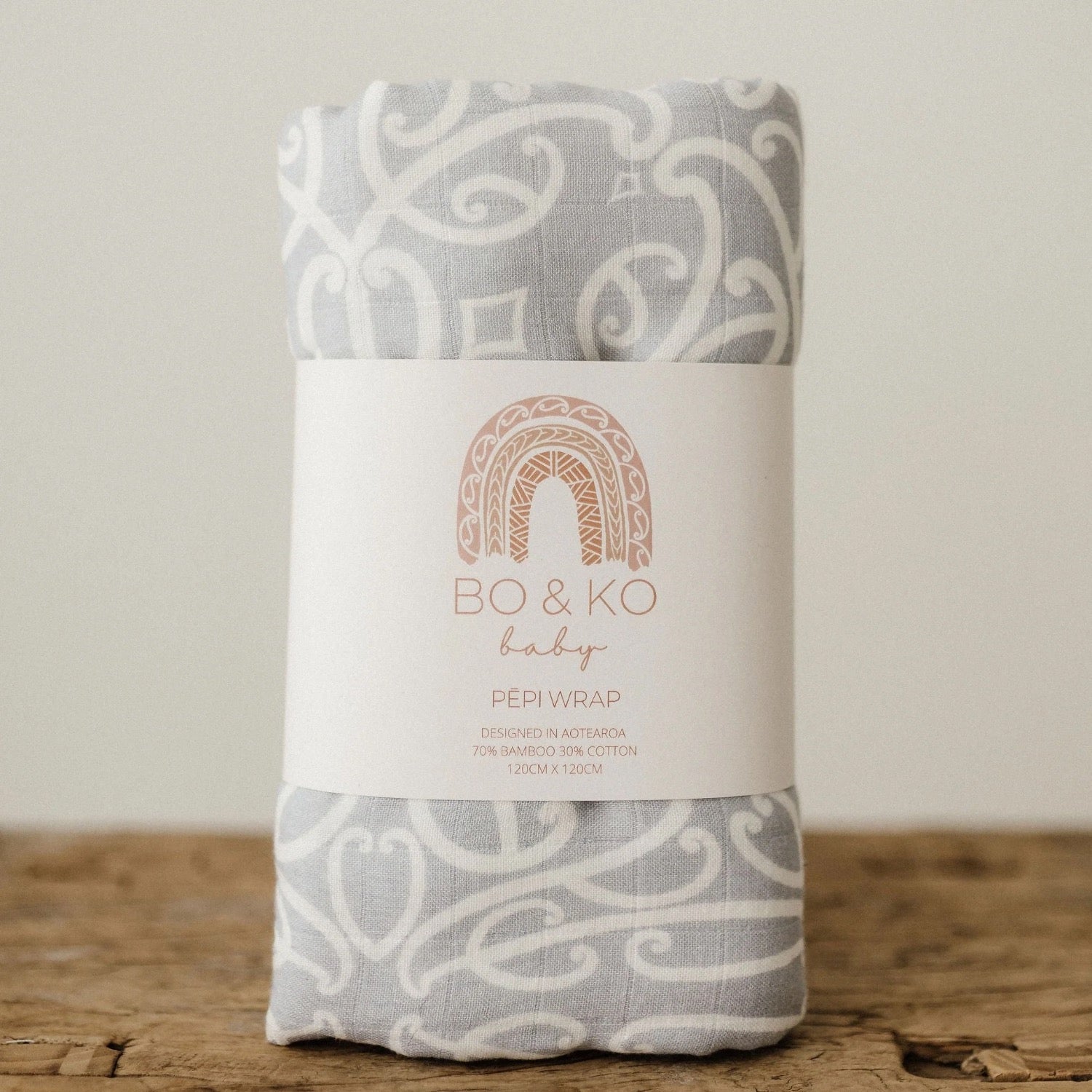 Folded baby wrap with 'Bo & Ko' label on a wooden surface