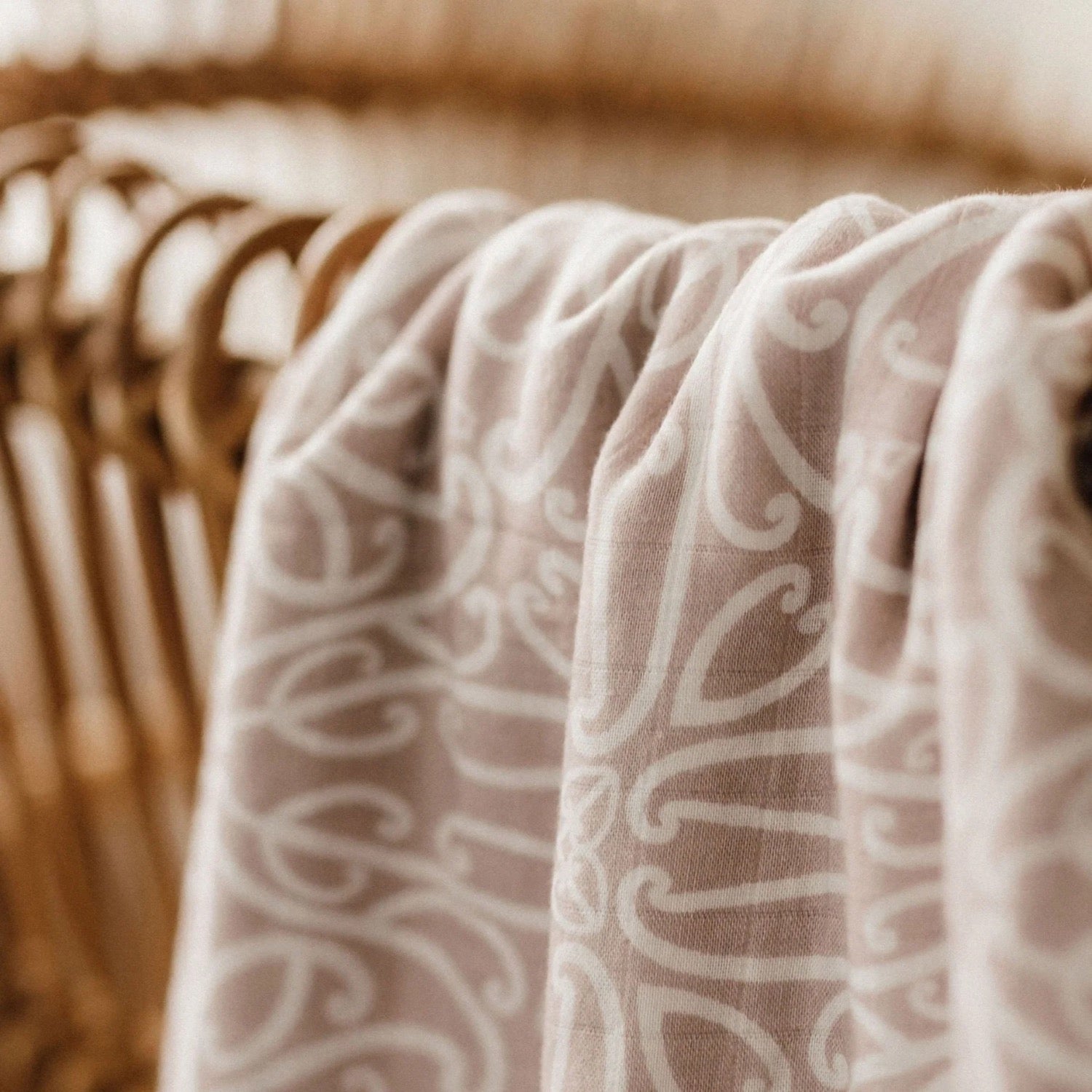 Folded baby wrap with a pattern and 'BO & KO baby' label on a wooden surface.