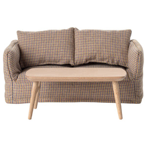 Plaid-patterned sofa with a wooden coffee table on a white background