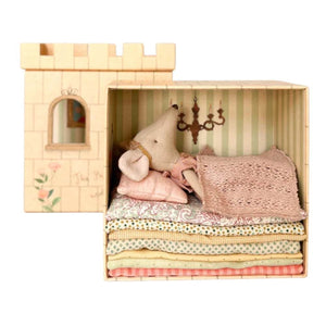 Wooden toy castle with a plush toy and fabric stacks inside