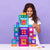 Child playing with colorful magnetic building blocks against a purple background