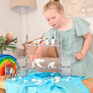 Child playing with a toy Arctic scene on a table