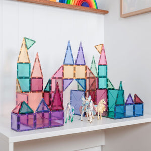 Colorful magnetic building blocks on a white shelf with toy horses.