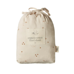 Beige drawstring bag with organic cotton fitted sheet label on a white background