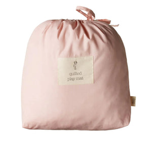 Pink quilted play mat with a label on a white background
