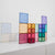Colorful transparent magnetic building blocks on a white surface with a light gray background