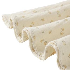 Folded beige fabric with small floral patterns on a white background