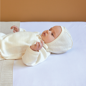 Baby wearing Nature Baby long sleeve pointelle kimono in natural colour and pointelle bonnet